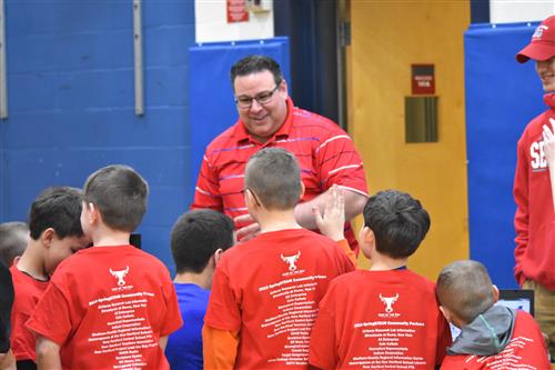 Students gathered around a teacher during a STEAM Fair