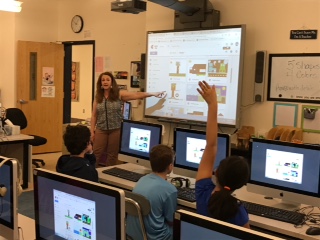 Mrs. Raynard with students at computers