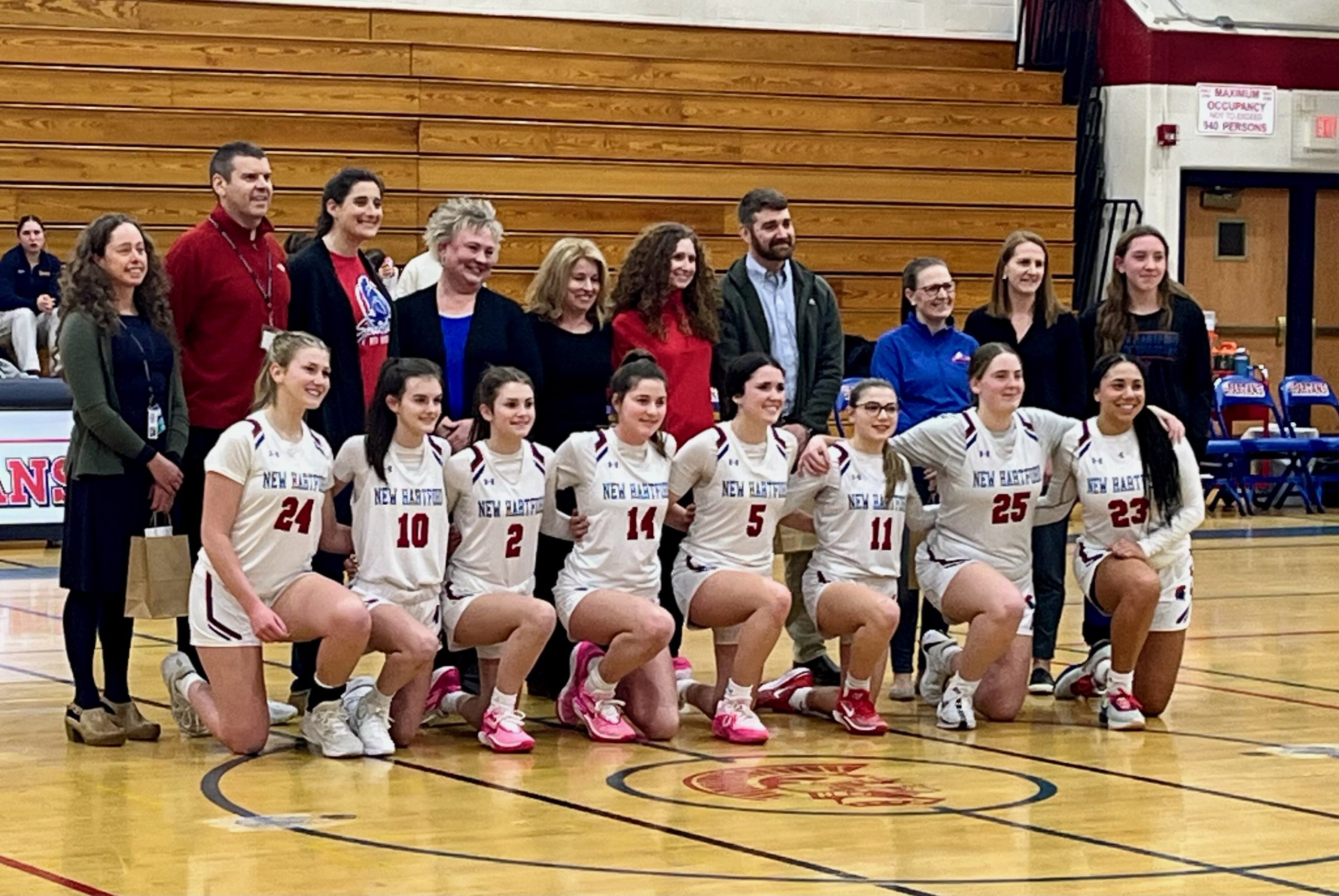 members of the team kneeling in front of teacher honorees, posing for a photo