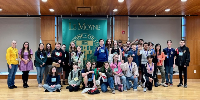Photo of New Hartford students at Latinalia competition with LeMoyne College banner in the background